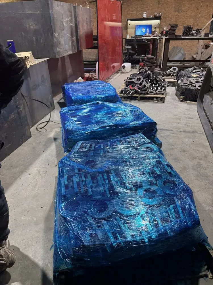 Finished parts wrapped in blue plastic on pallets