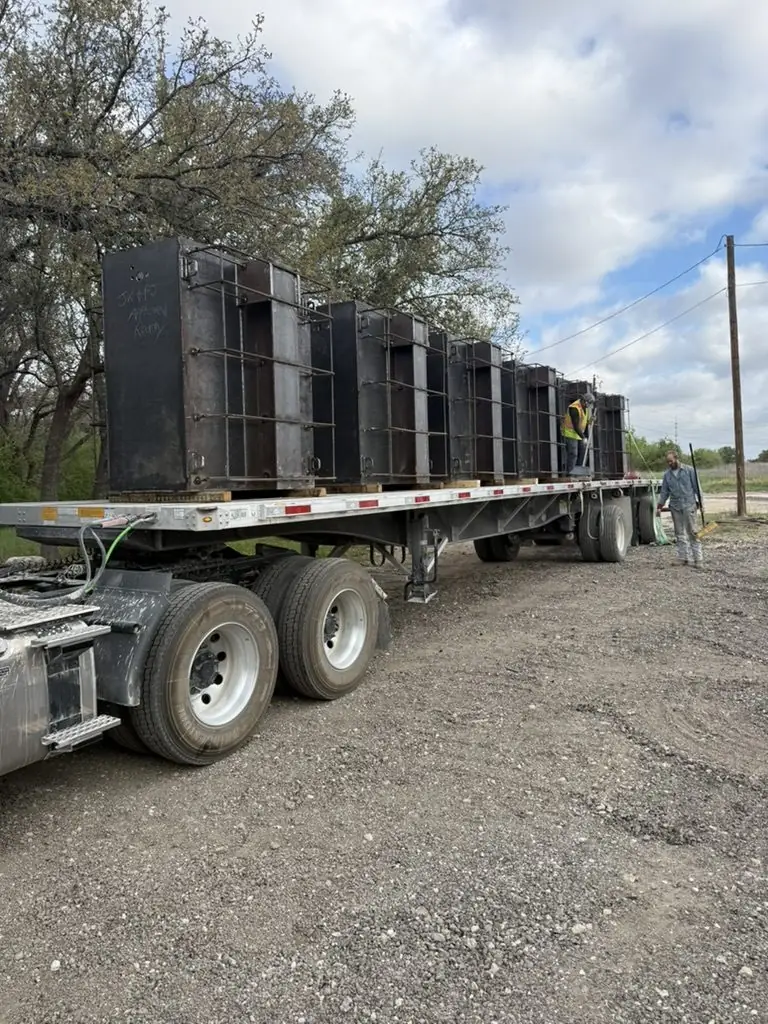 Flatbed loaded with a row of steel enclosures
