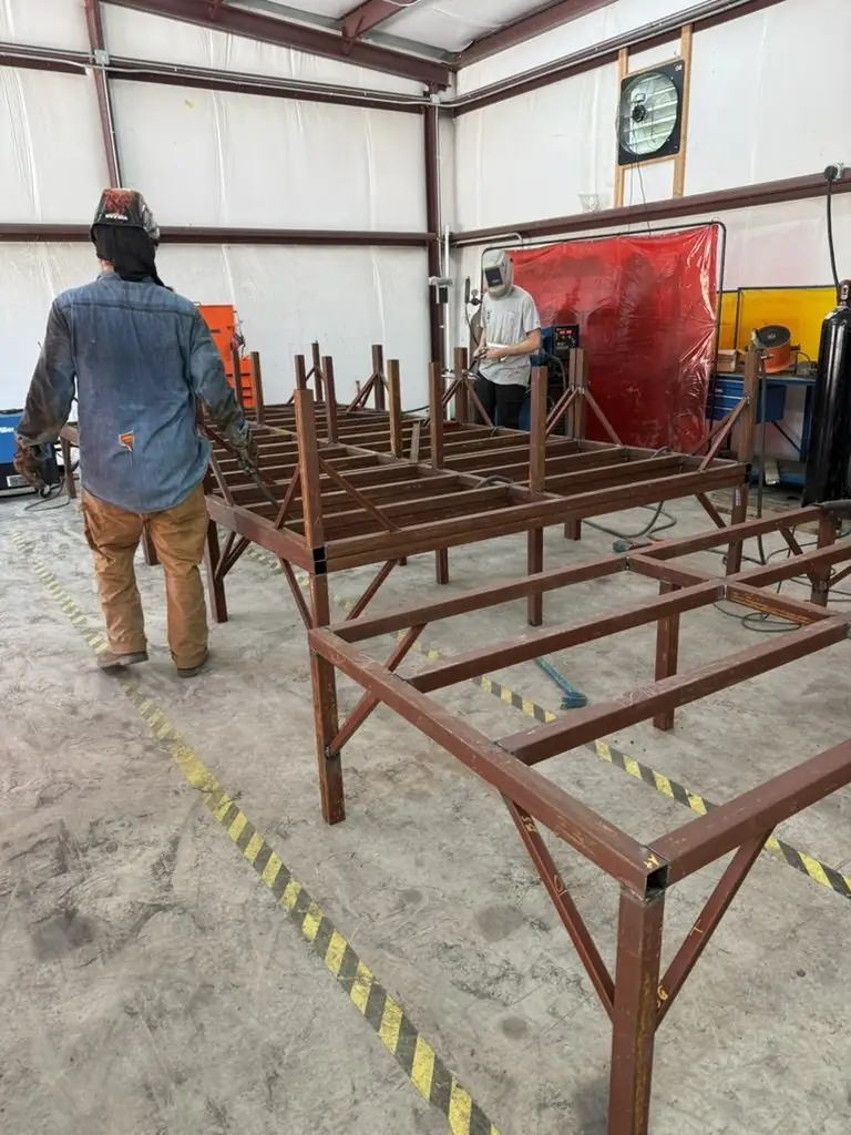 Crew building a long steel frame in the shop