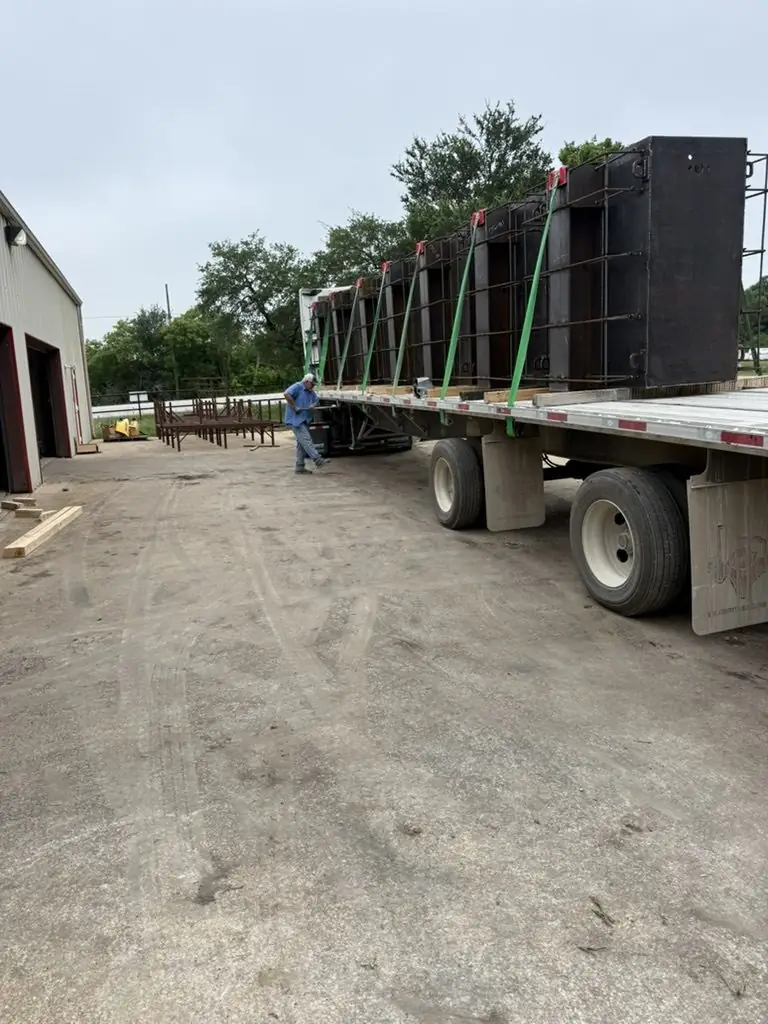 Flatbed trailer loaded with tall steel enclosures