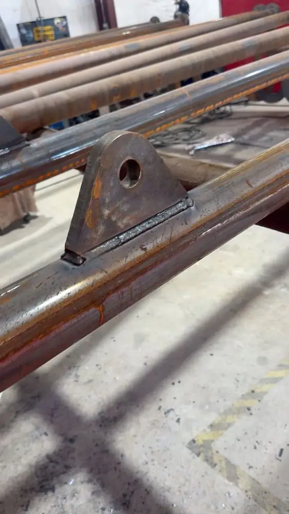 Lug tab welded to a pipe rail