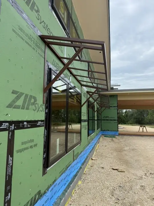 Steel awning frames mounted over windows on a new build