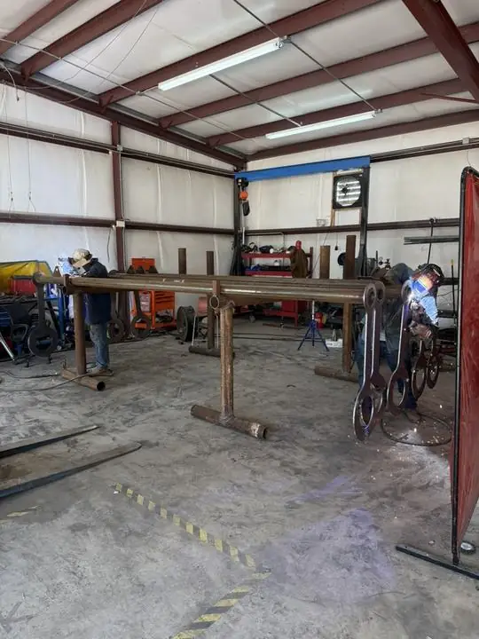 Two welders working a production run on shop stands
