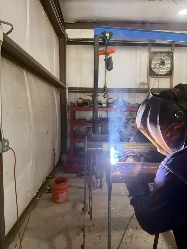Welder at work under the overhead hoist