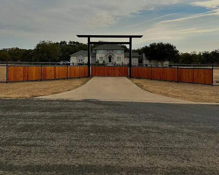 Steel entrance arch with cedar panel fence wings