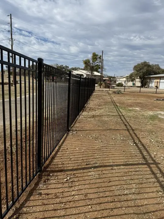 Ornamental steel fence line along the road