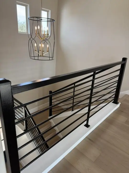 Black horizontal bar rail at upstairs stair landing