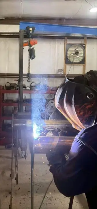 Welding pipe under the shop's overhead hoist
